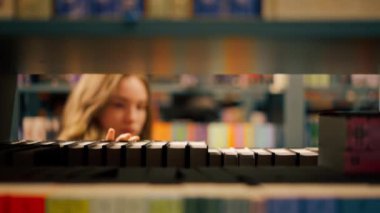 Bir kitapçıya kapandığında genç bir kız sınavlara hazırlanmak için kendine yeni bir kitap seçer.