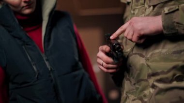 Profesyonel bir atış poligonu eğitimcisi bir kıza tabancayı nasıl kullanacağını söyler.