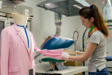 Profesyonel kuru temizlemeci. Genç bir kız kurutucudan elbisesini çıkartıyor.