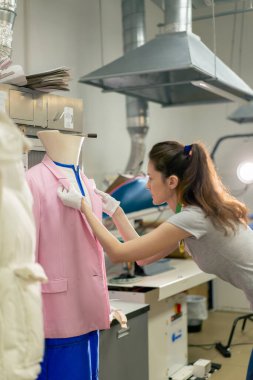 Profesyonel kuru temizlemeci. Genç bir kız kurutucudan elbisesini çıkartıyor.