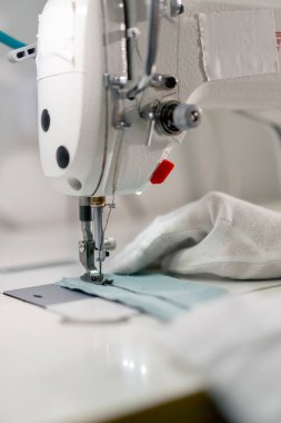 Profesyonel kuru temizlemeciyi kapat. Genç bir kız dikiş makinesiyle süveterini parçalıyor.