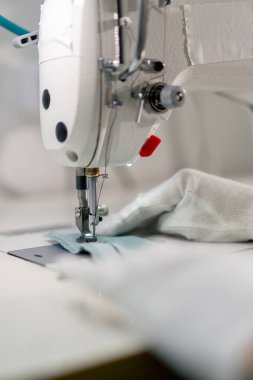 Profesyonel kuru temizlemeciyi kapat. Genç bir kız dikiş makinesiyle süveterini parçalıyor.