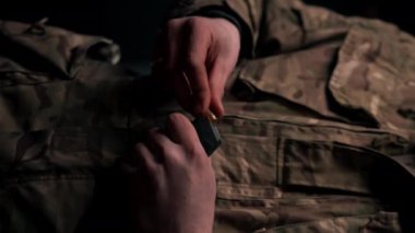 Profesyonel bir atış poligonunda dikey video çekimi. Bir askeri antrenör şarjörü mermilerle doldurur.