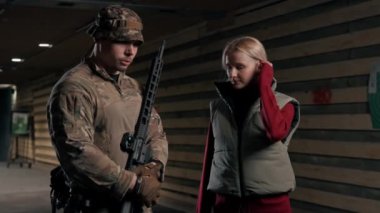 Profesyonel bir atış poligonunda bir askeri eğitmen bir kıza NATO silahlarını nasıl kullanacağını söyler.