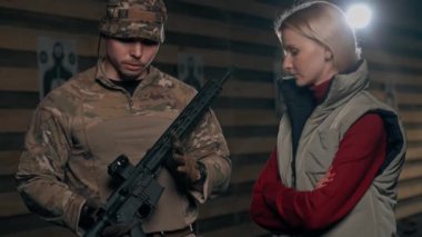 Profesyonel bir atış poligonunda askeri eğitimci bir kıza NATO silahlarını nasıl kullanacağını söyler.
