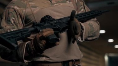 Profesyonel bir atış poligonunda askeri eğitimci bir kıza NATO silahlarını nasıl kullanacağını söyler.