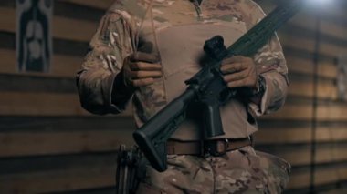Profesyonel bir atış poligonunda askeri eğitimci bir kıza NATO silahlarını nasıl kullanacağını söyler.