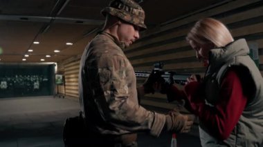 Profesyonel bir atış poligonunda bir askeri eğitmen bir kıza NATO silahlarını nasıl kullanacağını söyler.