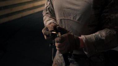 Profesyonel bir atış poligonunda bir asker şarjörünü fişeklerle donatır.