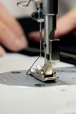 Dikiş atölyesine yakın çekim ipliği bir makinenin iğnesine yerleştirilir