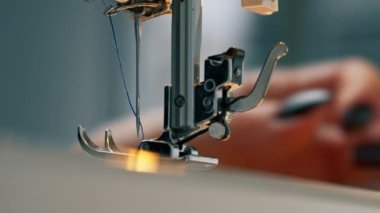 Dikiş atölyesine yakın çekim ipliği bir makinenin iğnesine yerleştirilir