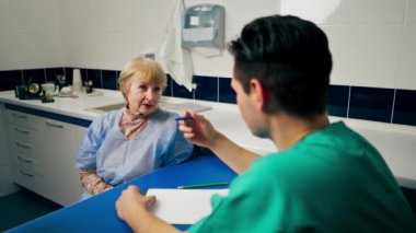 Estetik cerrahi kliniğinde bir doktor ve yaşlı bir hasta arasında danışma