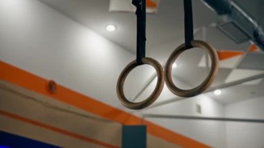 Spor kulübünde yakın plan, turuncu mavi arka plan, atletizm için ahşap halkalar asıyor.