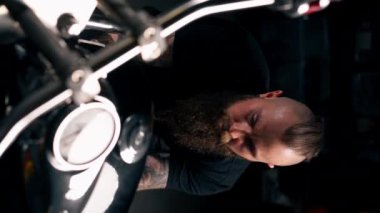 Bir motosiklet tamir atölyesinde dikey video kapanıyor. Filtreyi yeni bir parçayla değiştiriyor.