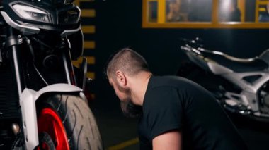 Bir motosiklet tamirhanesinde bir motosiklet için süspansiyon sistemi ön tekerleği tamir eder.