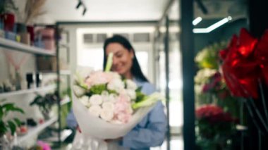 Bir çiçekçide bir çiçekçi, çiçeklerle tamamlanmış bir çiçek düzenlemesine hayran kalır.