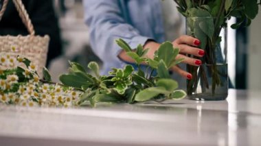 Çiçekçi dükkanını kapatın. Çiçekli bir kız gerekli çiçekleri ve çiçek aranjmanını seçer.