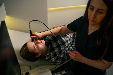 Bir göz hekiminde genç bir doktor genç bir kızın gözünün ultrasonunu çeker.