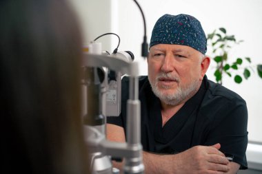 Optalmoloji kliniğine yakın bir yerde yaşlı bir doktor genç bir kızla vizyon hakkında bir danışma yapıyor.