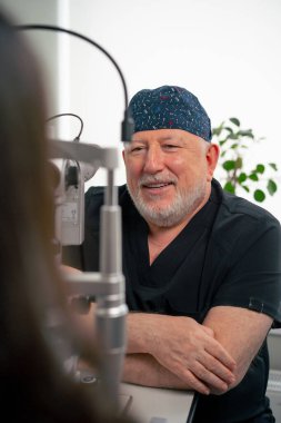 Optalmoloji kliniğine yakın bir yerde yaşlı bir doktor genç bir kızla vizyon hakkında bir danışma yapıyor.