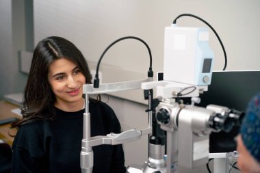 Bir göz doktoru kliniğinde yaşlı bir doktor genç bir kızla vizyon hakkında bir danışma yapıyor.