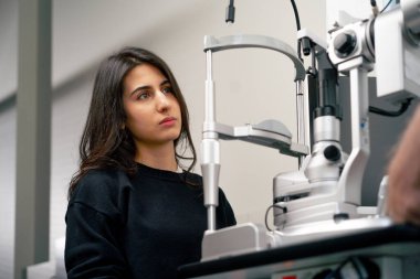 Bir göz doktoru kliniğinde yaşlı bir doktor genç bir kızla vizyon hakkında bir danışma yapıyor.