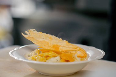 Profesyonel bir mutfakta beyaz tabak hazır carbonara makarnası.