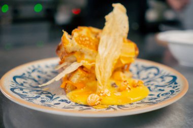 Profesyonel bir mutfağa yakın plan. Bir tabak peynirli tost. Kurutulmuş tavuk dilimleri.