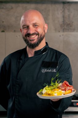 Profesyonel bir mutfakta şefin yanında Belçika usulü waffle kahvaltısı var. Kameraya bak.