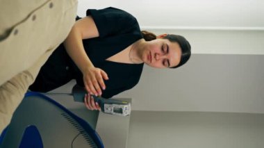 Kozmetik kliniğinde bir kız kozmetik uzmanı genç bir adamın yüzü için fotoğraf terapisi yapıyor.