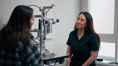 Bir göz hekiminde genç bir doktor genç bir kızla vizyon hakkında bir danışma yapar.