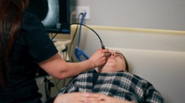 Bir göz hekiminde genç bir doktor genç bir kızın gözünün ultrasonunu çeker.