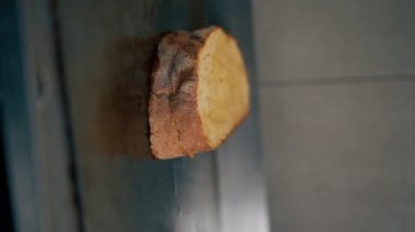 Profesyonel bir mutfakta, fırında peynirli tost yaparken çekilen dikey video. Şef spatulayla bastırıyor.