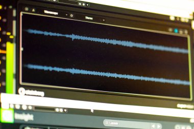 Karanlık bir kayıt stüdyosunda ses kaydı, temizlik, karıştırma ve işleme sesi olan bir monitör profesyoneller için özel bir programda.