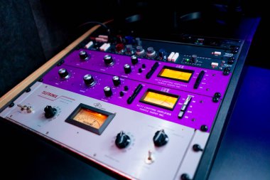 Kayıt odasını kapatın. Neon ışıkları, sesi ayarlamak ve ayarlamak için bir uzaktan kumanda. Birçok düğme.