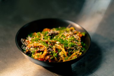 Profesyonel bir mutfağa yakın çekim. Masada siyah erişteli siyah viski var.