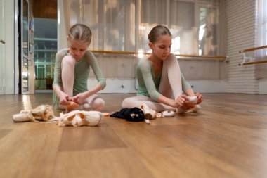 Profesyonel çocuk bale okulu. Balerinler yerde otururken sivri ayakkabılar giyerler.