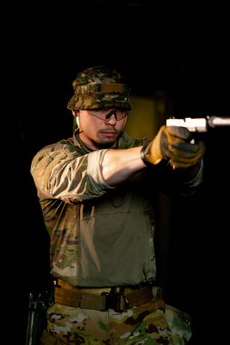 Profesyonel bir atış talimine yakın cephaneli askeri eğitimci silahla nişan alır.