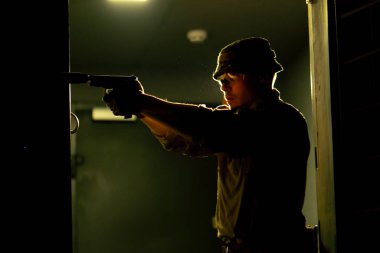 Profesyonel bir atış poligonunda bir askeri mühimmat eğitmeni silah doğrultuyor.