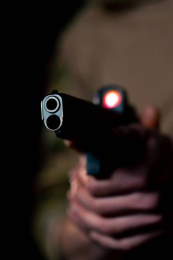 Profesyonel bir atış talimine yakın cephaneli askeri eğitimci silahla nişan alır.