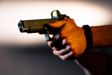 Profesyonel bir atış poligonunda yakın mesafeden ateş etmeye hazır bir silahı dolduran askeri eğitmen.