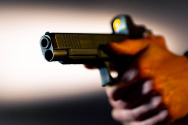 Profesyonel bir atış poligonunda yakın mesafeden ateş etmeye hazır bir silahı dolduran askeri eğitmen.