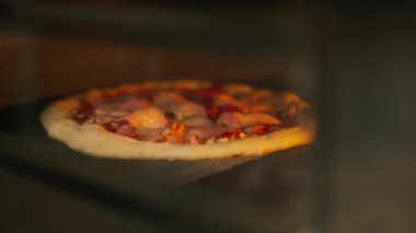 Profesyonel bir mutfakta, pizza ve pastırma fırında hazırlanır.