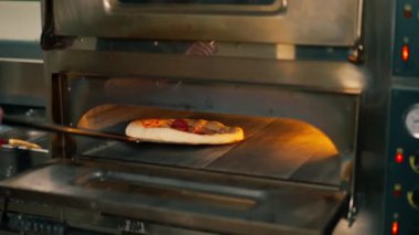 Profesyonel bir mutfakta, bir pizzacının içinde pastırma şefiyle birlikte fırında hazır.