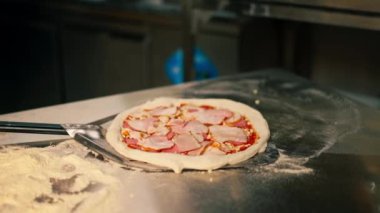 Profesyonel bir mutfakta, pizza ve pastırma fırında hazırlanır.
