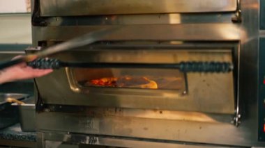 Bir pizzacının profesyonel mutfağında pastırmalı pizza fırından hazırlanır.