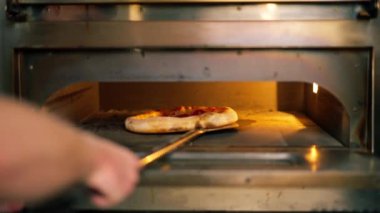 Bir pizzacının profesyonel mutfağında pastırmalı pizza fırından hazırlanır.