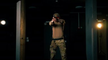 Profesyonel bir atış poligonunda askeri eğitmen ateş etmeye hazır bir silahı dolduruyor. 