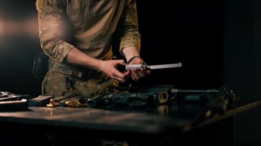 Profesyonel bir atış poligonunda profesyonel bir savaşçı bir NATO saldırı tüfeği kuruyor.