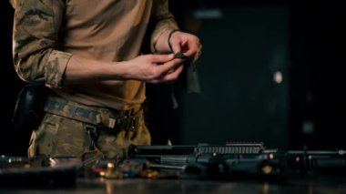 Profesyonel bir atış poligonunda profesyonel bir savaşçı bir NATO saldırı tüfeği kuruyor.
